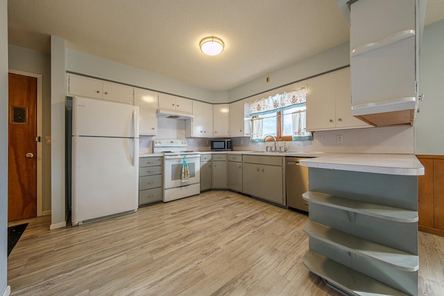 kitchen with white appliances, a sink, white cabinetry, light wood-style floors, and light countertops