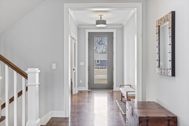 entrance foyer featuring dark wood-type flooring, ornamental molding, and a healthy amount of sunlight