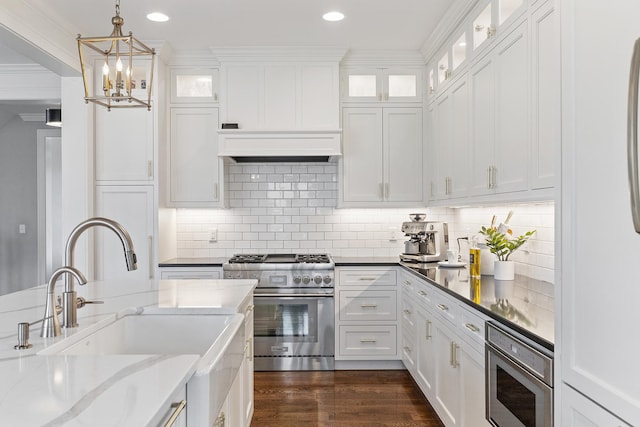 kitchen featuring white cabinetry, appliances with stainless steel finishes, and dark stone counters