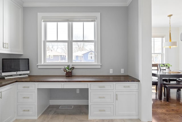 office space with crown molding and built in desk