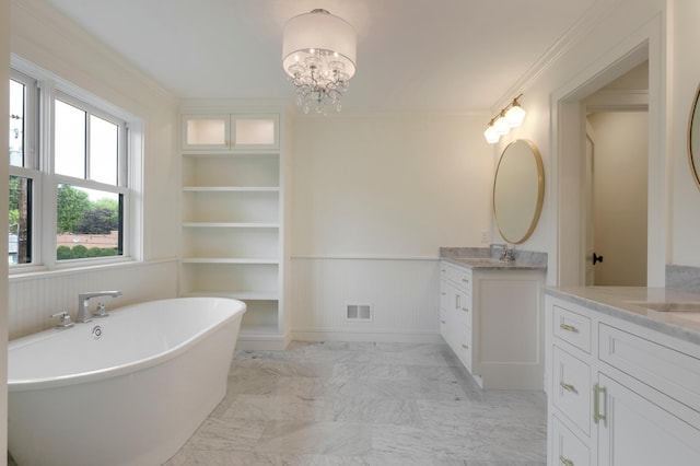 bathroom featuring vanity, ornamental molding, a notable chandelier, a bath, and built in shelves