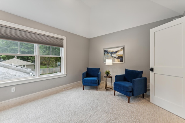 living area with lofted ceiling and light colored carpet