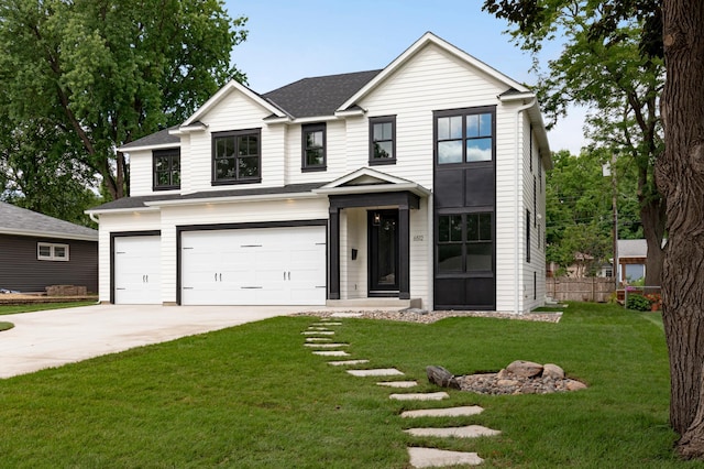 view of front of house featuring a garage and a front lawn