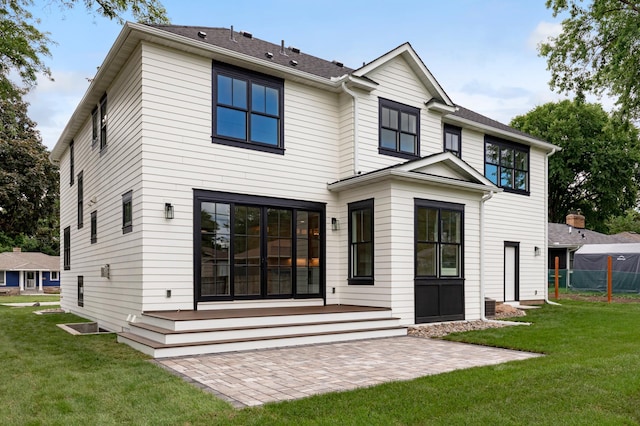 rear view of house with a patio area and a lawn