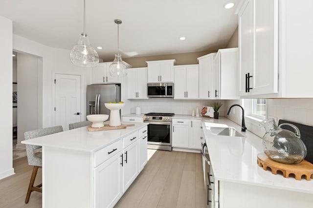 kitchen featuring stainless steel appliances, a breakfast bar, a sink, and backsplash