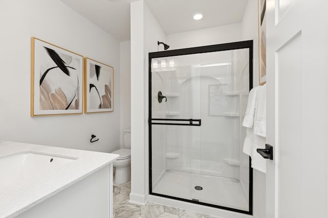 bathroom featuring marble finish floor, a shower stall, toilet, and vanity