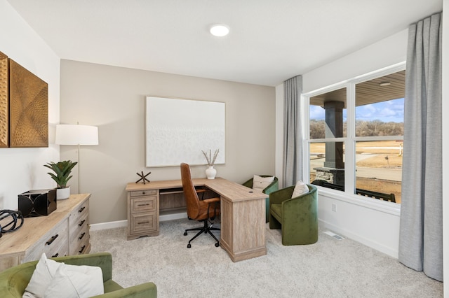 office with baseboards, visible vents, and light colored carpet