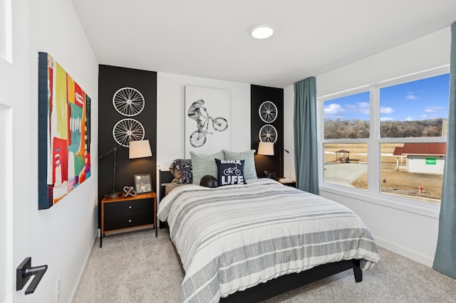 bedroom featuring light colored carpet and baseboards