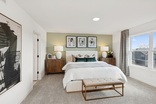 bedroom with light carpet, visible vents, and baseboards