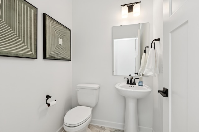 bathroom with toilet and baseboards