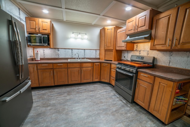 3835 Lake Rd, Barnum Twp, MN 55767 - kitchen with stainless steel appliances, under cabinet range hood, a sink, dark countertops, and brown cabinetry