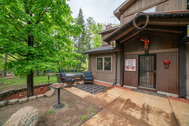 3835 Lake Rd, Barnum Twp, MN 55767 - view of exterior entry featuring a patio, a chimney, and outdoor lounge area