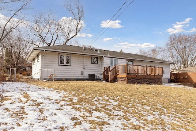 snow covered rear of property featuring a yard, a deck, and central air condition unit