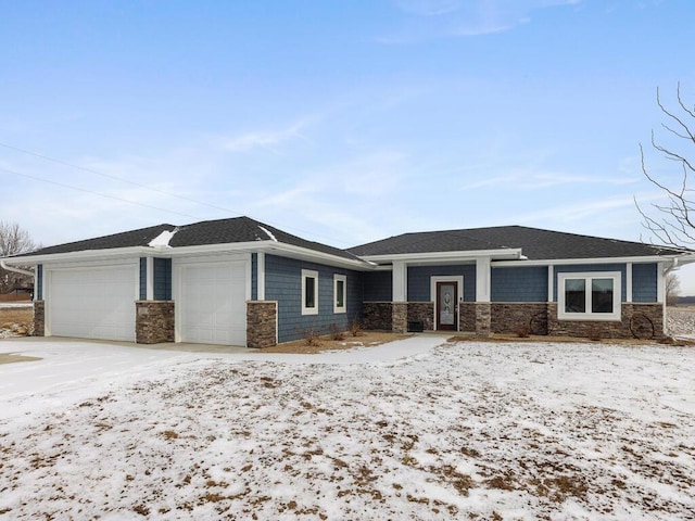 prairie-style home with a garage, stone siding, and driveway