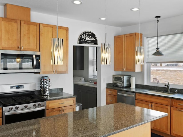 kitchen with pendant lighting, dark stone counters, recessed lighting, stainless steel appliances, and a sink