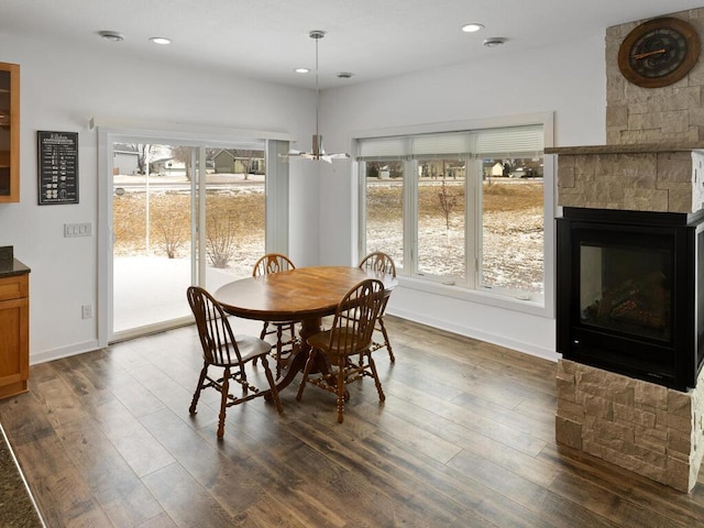 dining room featuring a healthy amount of sunlight, a chandelier, and dark wood-style flooring