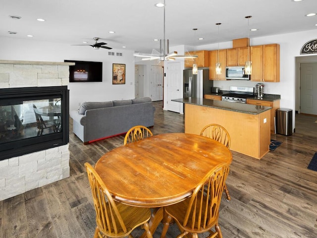 dining space with visible vents, dark wood finished floors, recessed lighting, a fireplace, and ceiling fan