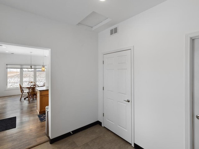 hallway with wood finished floors, baseboards, and visible vents