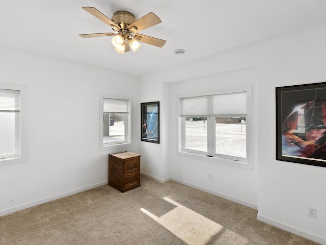 unfurnished bedroom with light colored carpet, baseboards, and ceiling fan