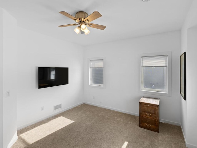 unfurnished bedroom with a ceiling fan, carpet, visible vents, and baseboards