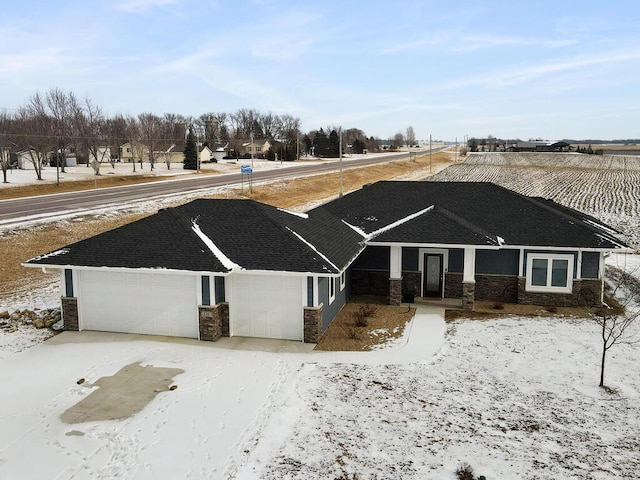 view of front of home featuring stone siding, an attached garage, concrete driveway, and roof with shingles