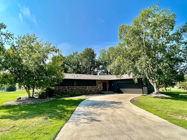 ranch-style house featuring a garage and a front lawn