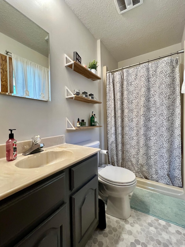 bathroom with vanity, toilet, and a textured ceiling