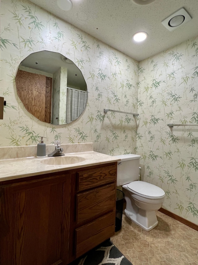 bathroom featuring vanity, toilet, tile patterned flooring, and a textured ceiling