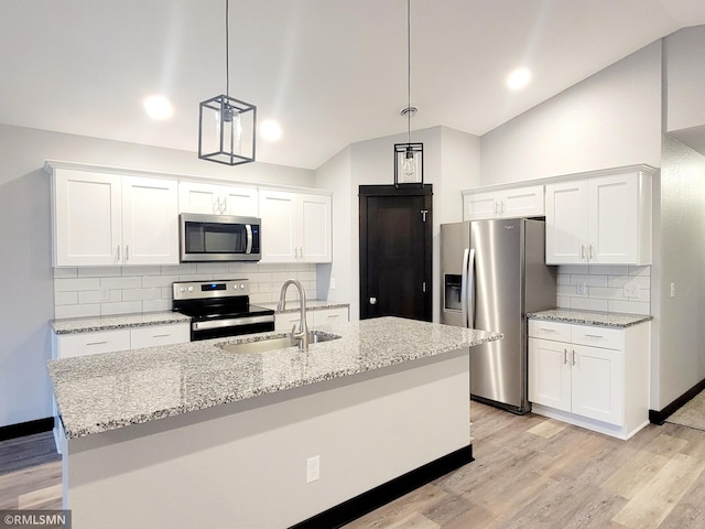 kitchen with vaulted ceiling, appliances with stainless steel finishes, sink, and pendant lighting