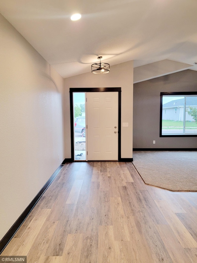 foyer with vaulted ceiling and light wood-type flooring