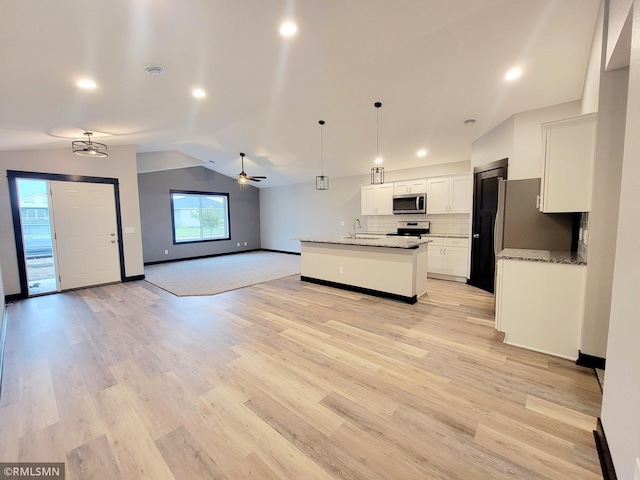 kitchen featuring white cabinetry, tasteful backsplash, vaulted ceiling, pendant lighting, and stainless steel appliances