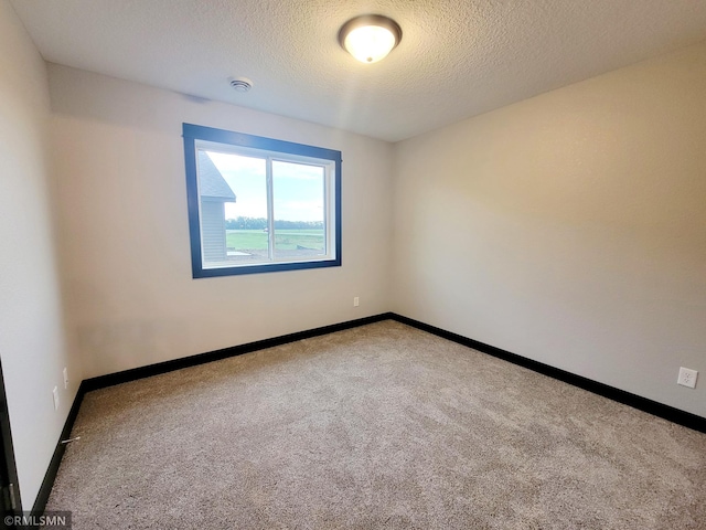 carpeted spare room featuring a textured ceiling