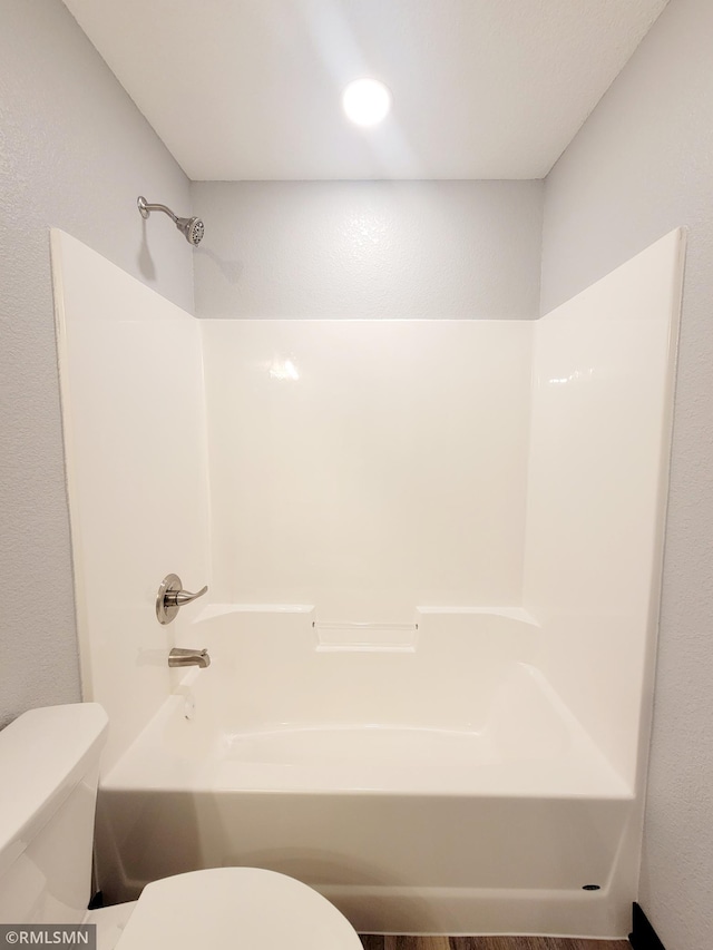 bathroom with toilet, shower / bath combination, and hardwood / wood-style floors