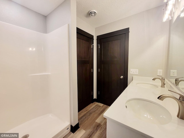 bathroom with wood-type flooring, vanity, and a textured ceiling