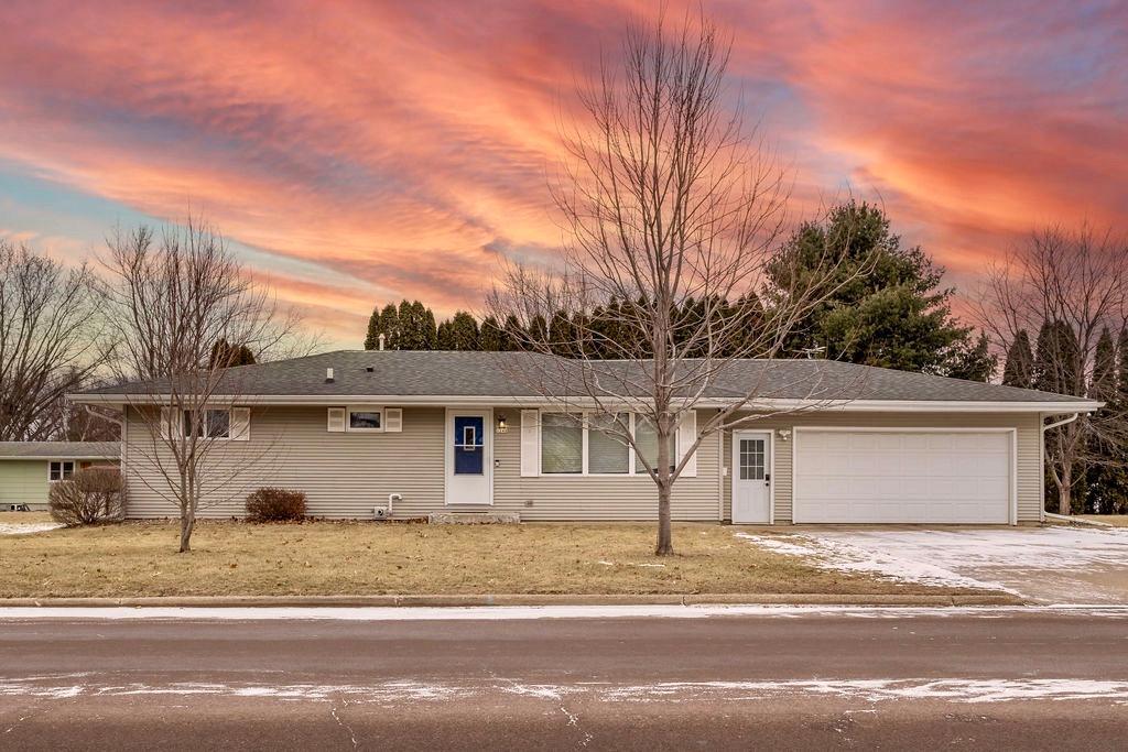 single story home featuring a garage and a lawn