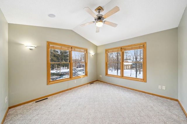 carpeted spare room featuring ceiling fan and vaulted ceiling