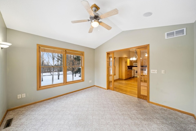 carpeted spare room featuring ceiling fan and lofted ceiling