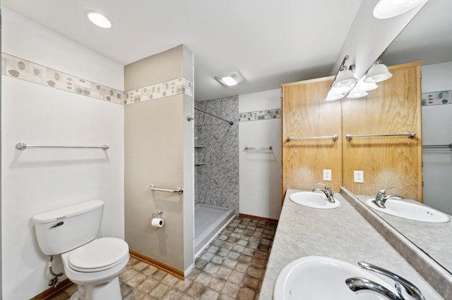 bathroom featuring vanity, toilet, and a tile shower