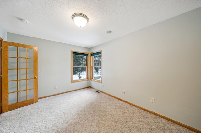 carpeted empty room featuring a textured ceiling