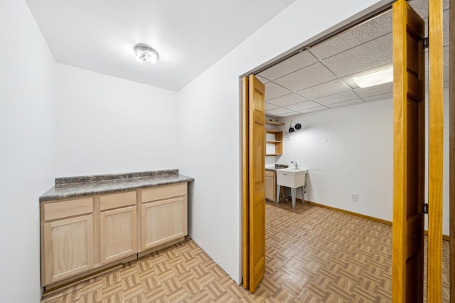 interior space featuring parquet floors, a paneled ceiling, and sink