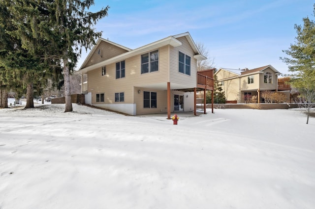 snow covered house featuring a wooden deck