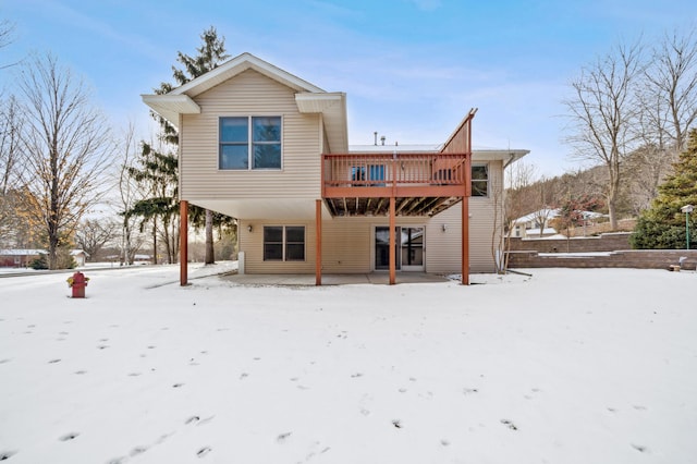 snow covered property with a deck