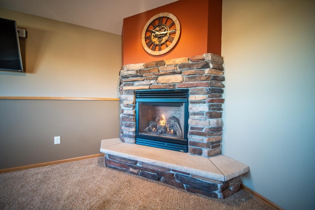 interior details featuring a stone fireplace and carpet