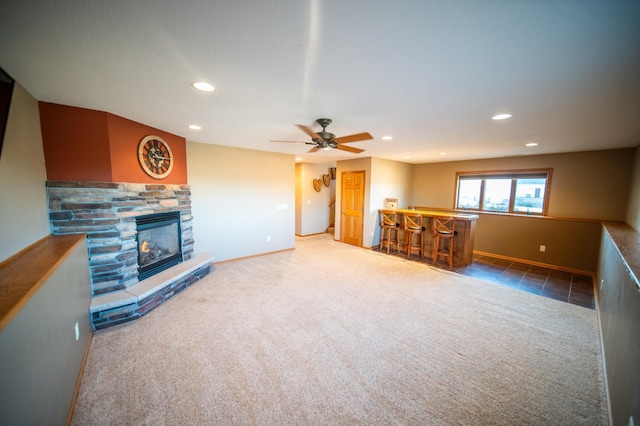 carpeted living room featuring ceiling fan, indoor bar, and a fireplace