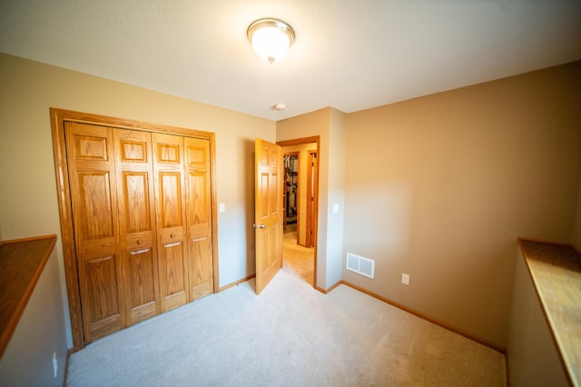 bedroom featuring light colored carpet and a closet