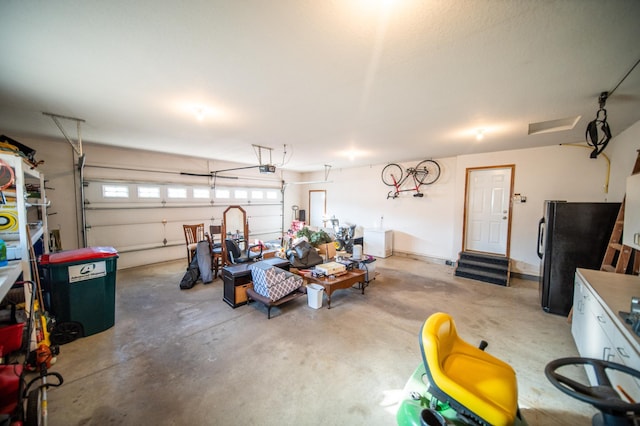 garage featuring black refrigerator and a garage door opener