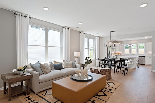 living room with a chandelier and light wood-type flooring