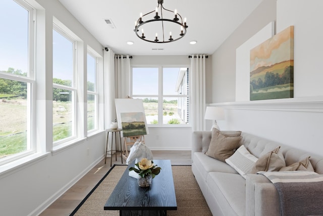 living room with a healthy amount of sunlight, a chandelier, and hardwood / wood-style floors