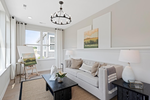 living room with a chandelier and light wood-type flooring