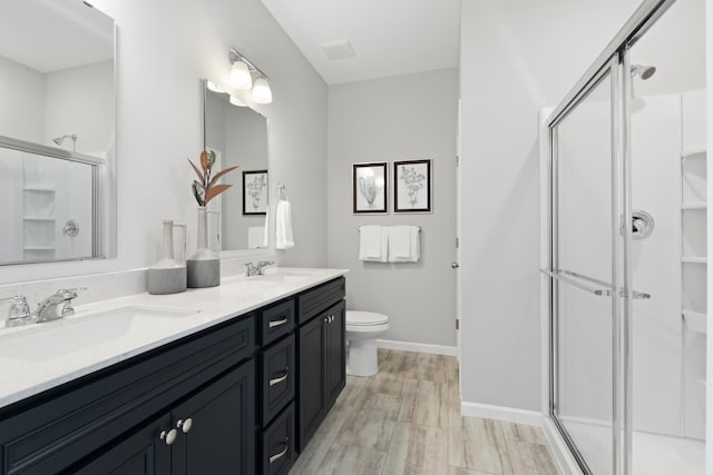 bathroom with vanity, toilet, an enclosed shower, and wood-type flooring